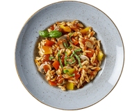 Eine Schüssel HOFMANNs Gulaschpfanne mit Tomatensoße, Champignons, Paprika und frischem Basilikum.