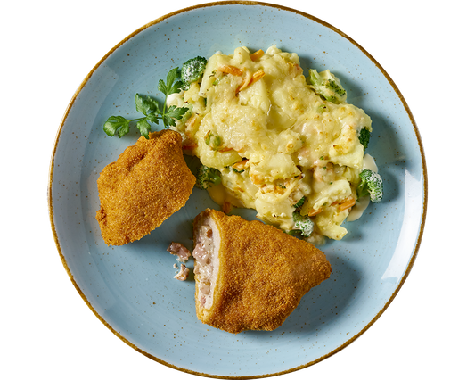 Eine Portion Schnitzel „Elsässer Art“ aus Hofmanns Shop und ein Käse-Brokkoli-Auflauf auf einem blauen Teller auf einem gewebten Tischset, begleitet von einem köstlichen hausgemachten Kartoffel-Gemüsegratin.