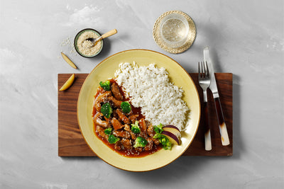 Schweinegeschnetzeltes "Asia Style" von Hofmanns Shop mit Reis, Gemüse und Getränk.