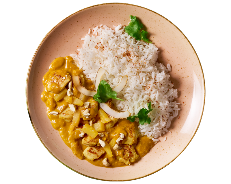 HOFMANNs Kokoshuhn: Basmati-Reis mit gelbem Curry, garniert mit Koriander, Kokos und Cashewnüssen.