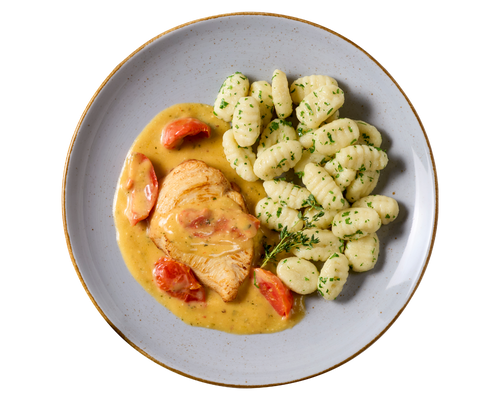 Sahne-Tomaten-Hähnchen von HOFMANNs mit Kräuter-Gnocchi auf einem grauen Teller.