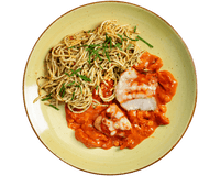 Teller mit mediterranen Kräuter-Spaghetti mit Hofmanns Shop Hähnchenbrust „Caprese“ in Tomatensauce.