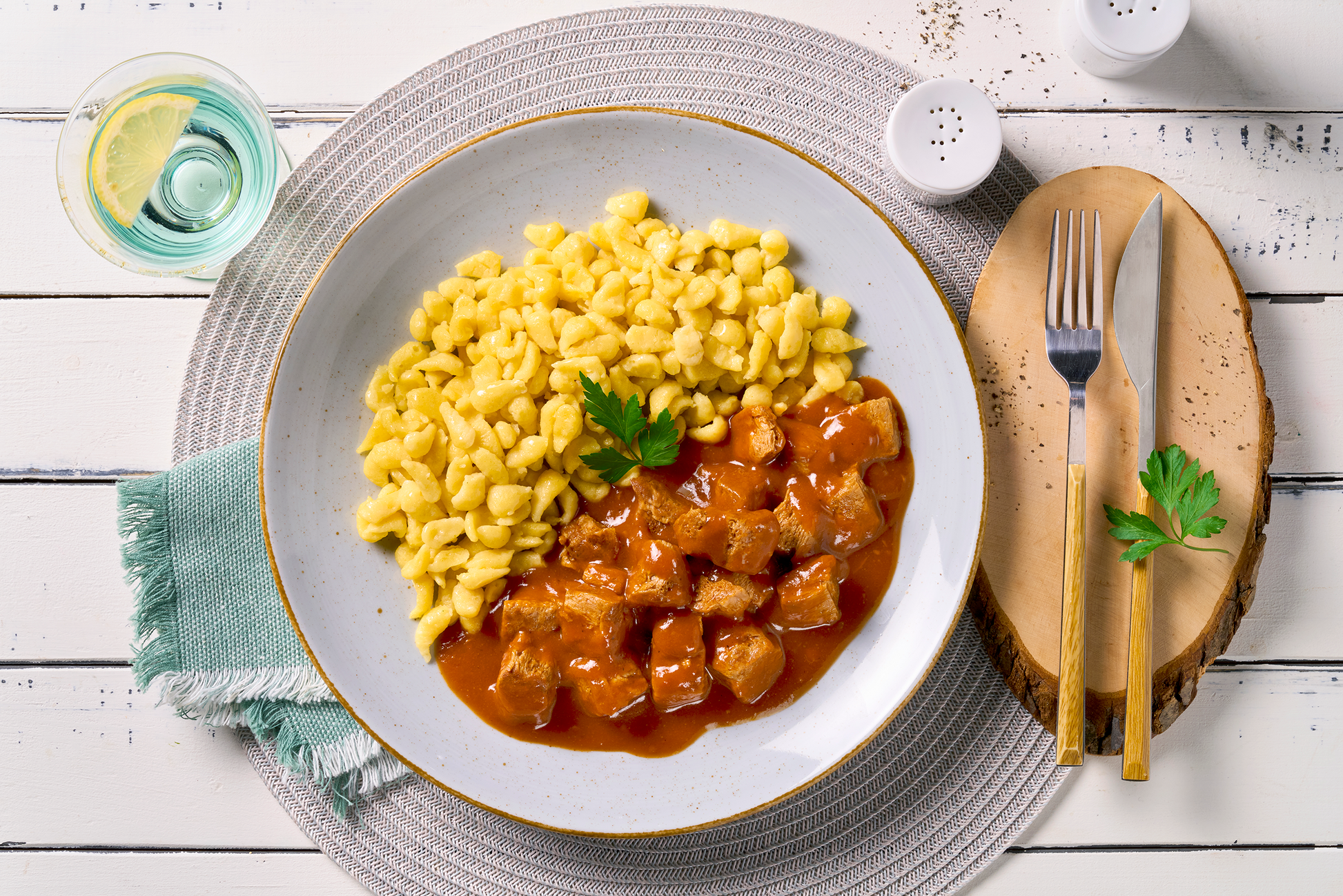 Ein Teller mit gepflanzten Steakhäppchen "Gulasch Style" von Hofmanns Shop mit Eierspätzle und Petersilie.