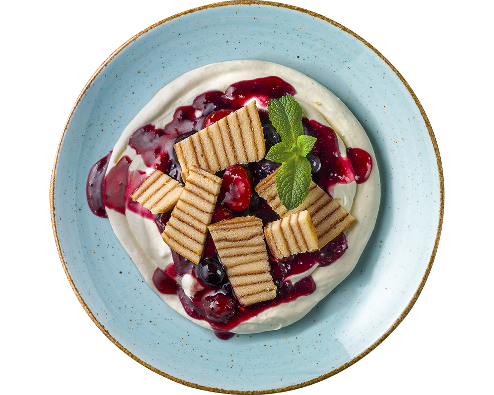 Dessert bestehend aus Baumkuchenstücken auf Mascarpone-Creme, ergänzt durch Beerensauce, Schichtwaffeln und garniert mit Minze auf einem blauen Teller von Hofmanns Shop.