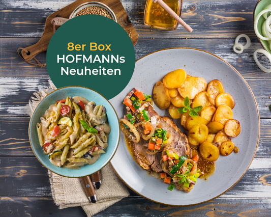 Ein Menü mit Aufschnitt, Bratkartoffeln und Nudelsalat auf einer rustikalen Tafel bietet mit den HOFMANNs Neuheiten von Hofmanns Shop Restaurant-Qualität.