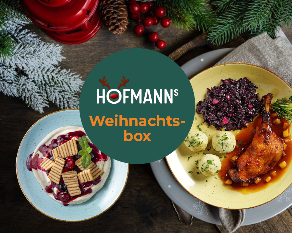 Genießen Sie ein festliches Festmahl mit traditionellen Weihnachtsgerichten wie Ente, Knödel und Rotkohl, gekonnt angerichtet in der HOFMANNs Weihnachts-Box aus Hofmanns Shop und abgerundet mit einem köstlichen Dessert.