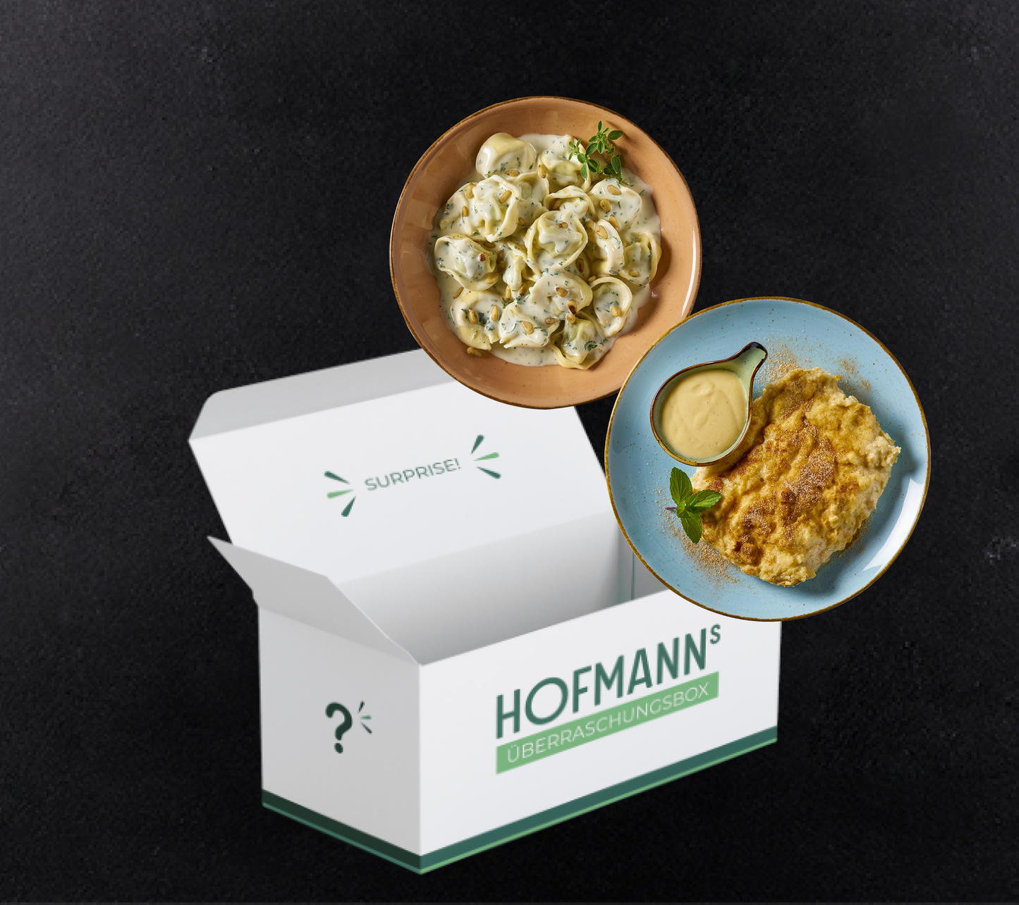 HOFMANNs Überraschungsbox mit köstlichen Knödeln und einem Käsegericht, elegant auf Tellern vor schwarzem Hintergrund präsentiert, verspricht Köstlichkeiten in Restaurantqualität, die perfekt für jeden Gourmet-Anlass sind.