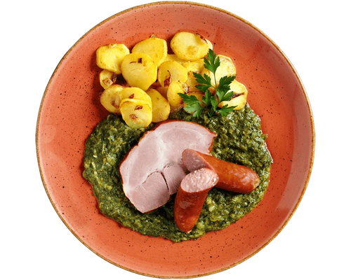 Ein Teller mit HOFMANNs Grünkohl „Norddeutsche Art“, Würstchen, Bratkartoffeln und cremigem Spinat.