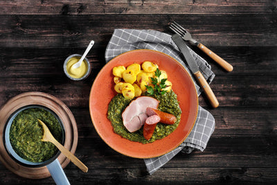Ein Teller mit HOFMANNs Neuheiten: geräuchertes Schweinefleisch, Wurst und Grünkohl-Eintopf in echter Restaurantqualität.