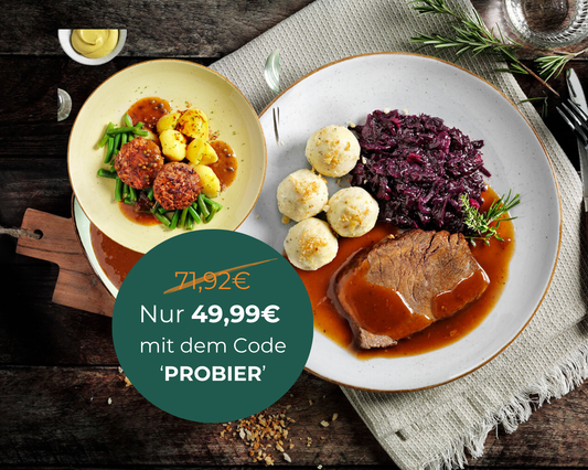 Zwei Teller HOFMANNs Herzhafte Küche mit Rindfleisch und Kartoffeln auf einem rustikalen Holztisch.