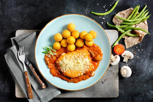HOFMANNs Schnitzel-Box „Schwäbische Spezialitäten“: Schnitzel, Kartoffelbällchen, Bohnen, Pilze, Tomate.