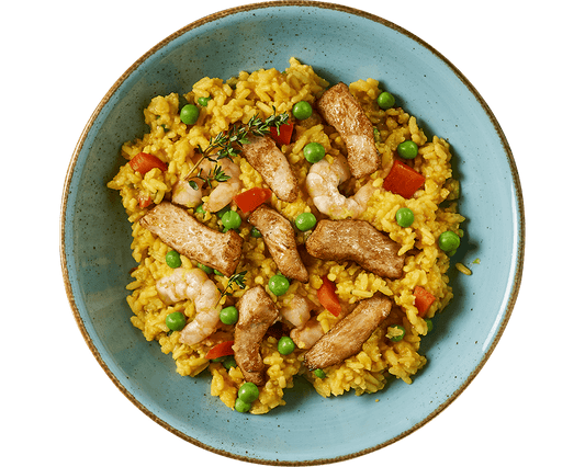 Eine Schüssel Paella von Hofmanns Shop mit buntem Reis, Garnelen, Hühnchen, Erbsen, roter Paprika und einem Zweig Thymian garniert zeigt das Beste der mediterranen Küche.