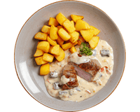 Gebratenes Lammhüftsteak von Hofmanns Shop mit Beilage und Gemüse auf dem Teller serviert.