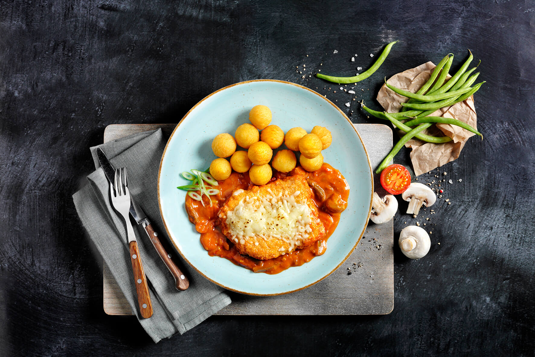 Ein Teller Frikadellen-Eintopf mit goldbraun gebratenen Kartoffeln, grünen Bohnen, Tomaten und Champignons als Beilage – eine echte Hofmanns Shop Protein Deluxe-Box für jeden Kraftsportler.